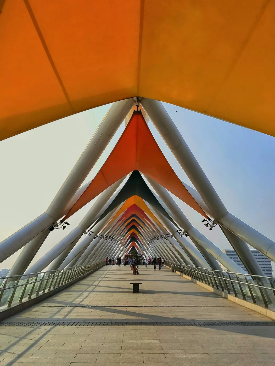 A pedestrian bridge with an orange canopy in Ahmedabad