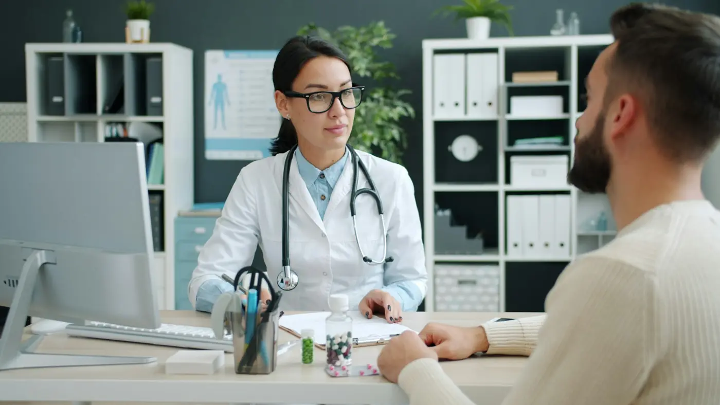 A doctor consulting with a patient at her clinic desk