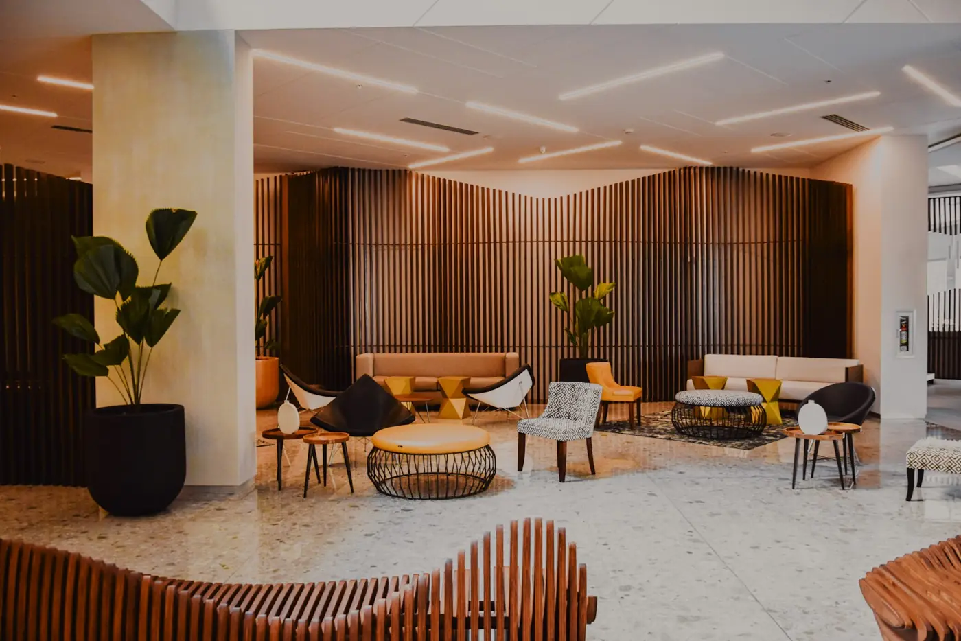 A modern hotel lobby with lounge seating and wood panelling