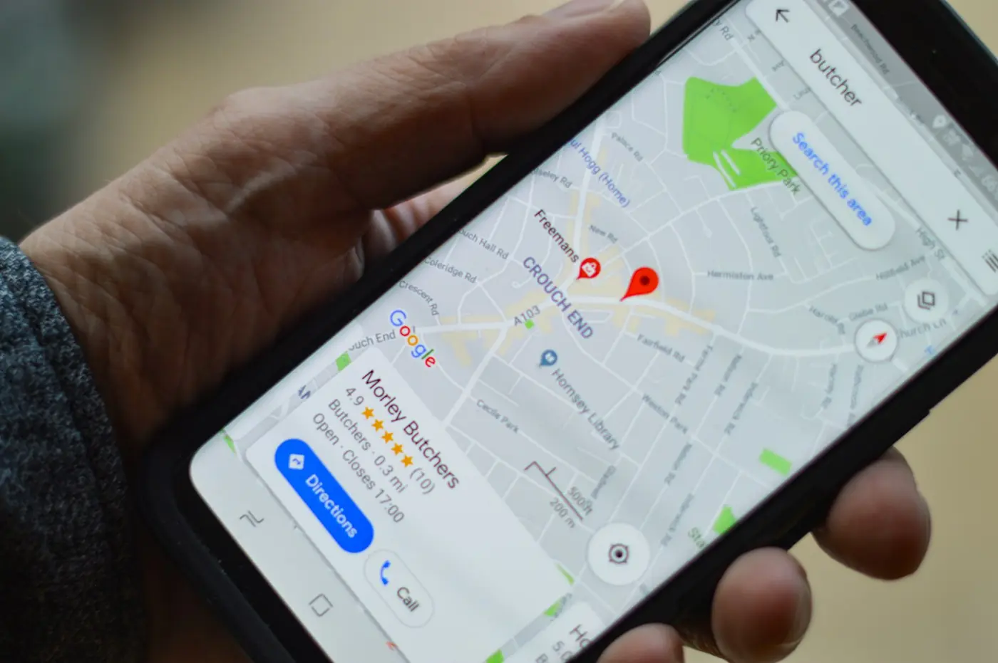 A phone showing a map with nearby businesses pinned