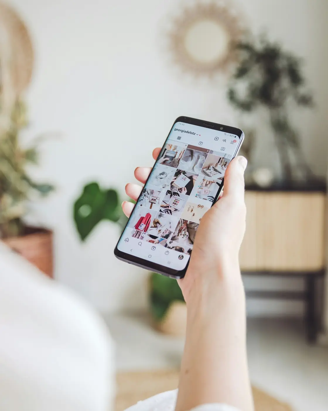 A hand scrolling an image feed on a smartphone