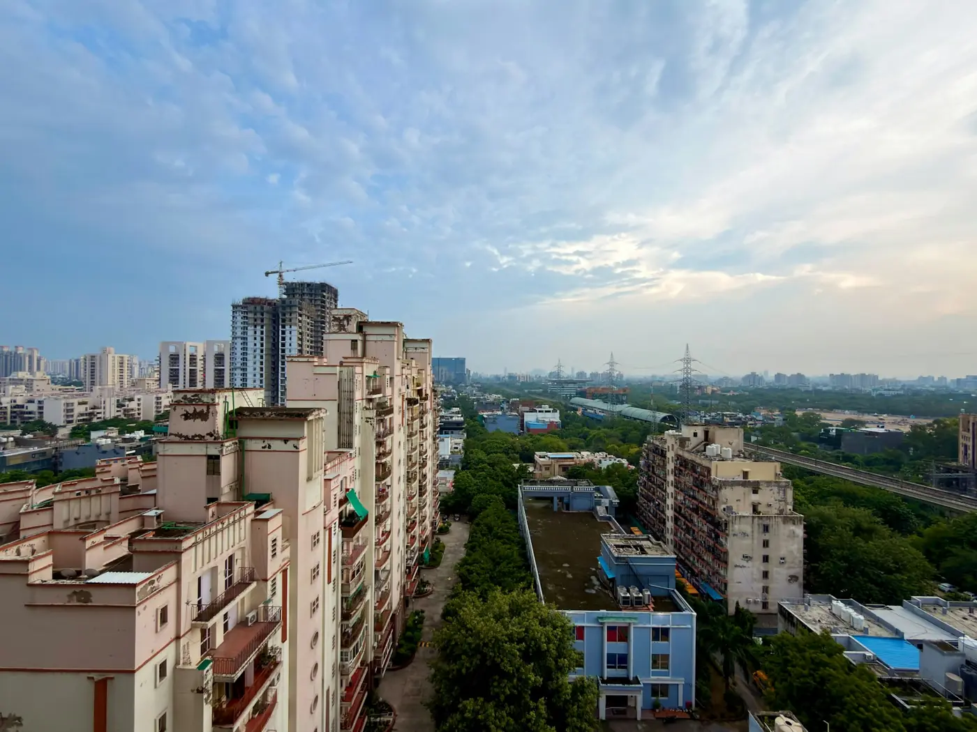 High-rise apartment buildings beside a green corridor in an Indian city
