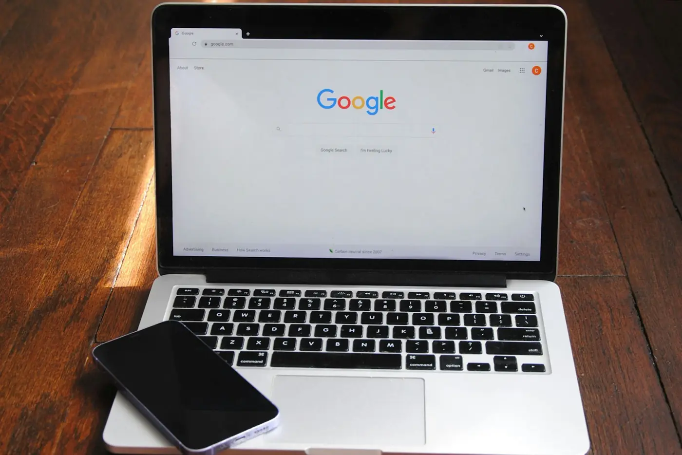 A laptop open on a search page with a phone beside it
