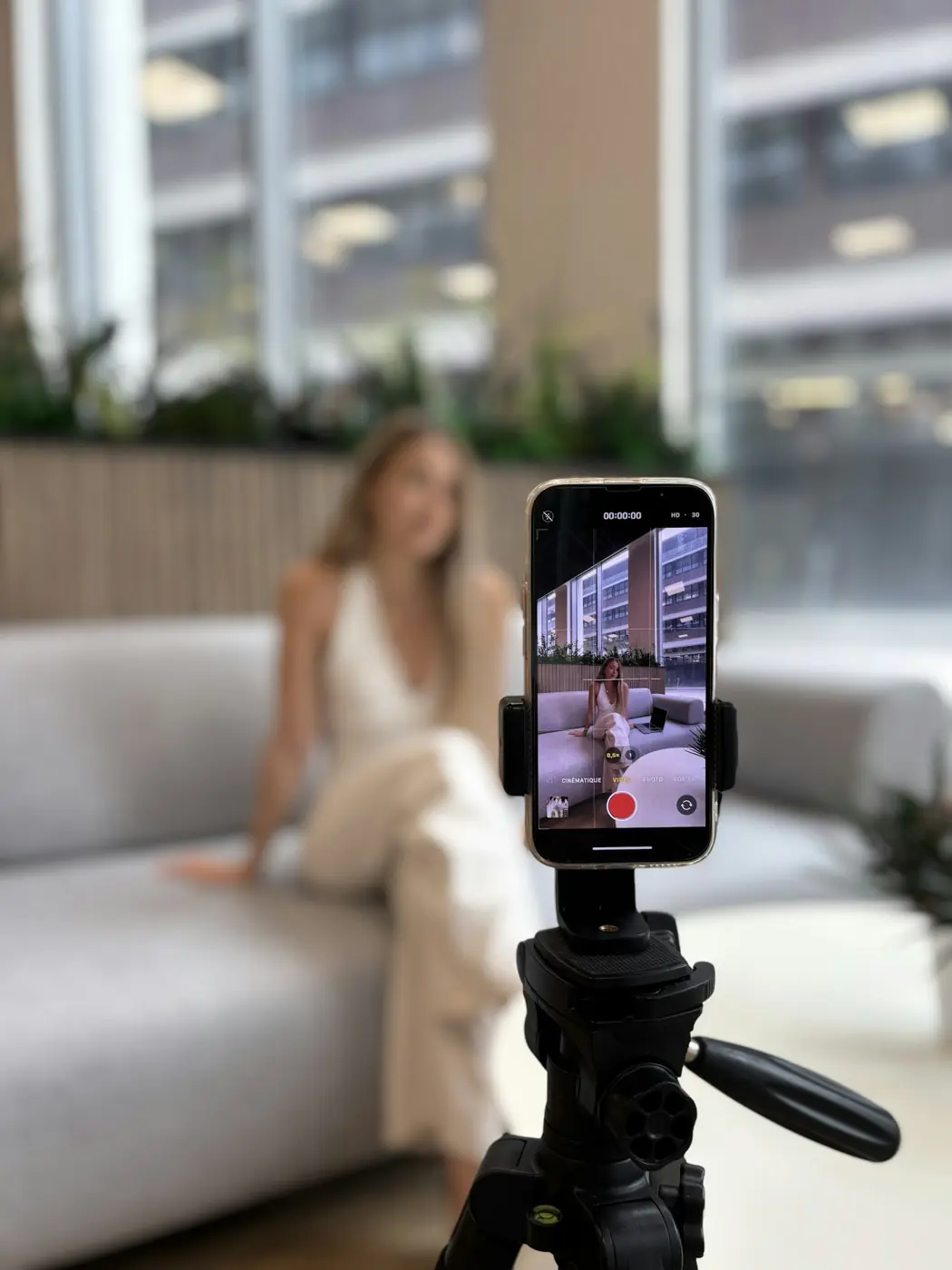 A creator recording a video on a phone mounted on a tripod