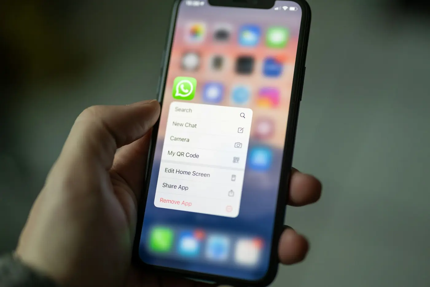 A hand holding a phone with a messaging app open